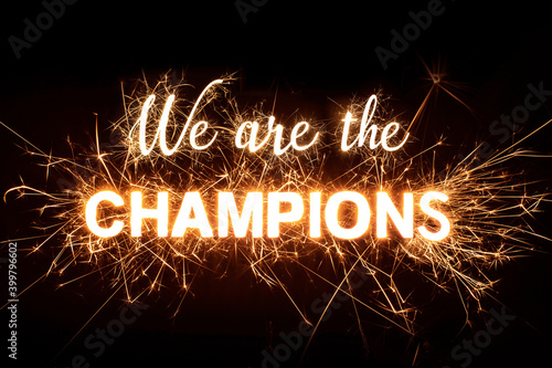Leinwand Poster 'We Are The Champions' in dazzling sparkler effect on dark background