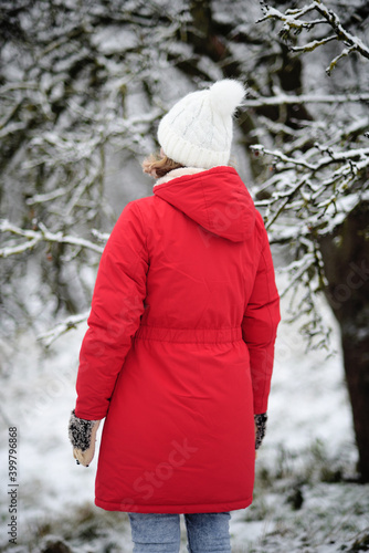 
Girl in a red winter coat and a white hat from the back