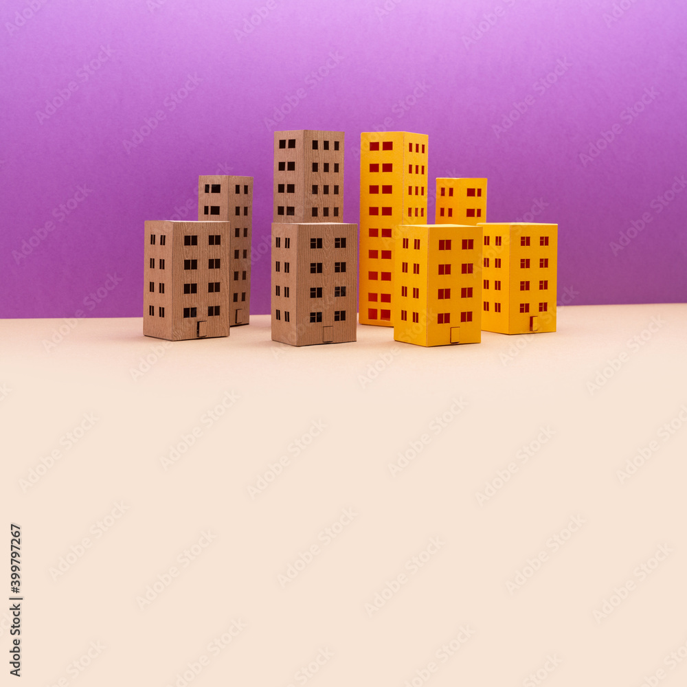 Naklejka premium Miniature city with yellow brown houses on purple beige background. Abstract urban architecture landscape, simplified town layout with high-rise buildings, skyscrapers with many windows. copy space