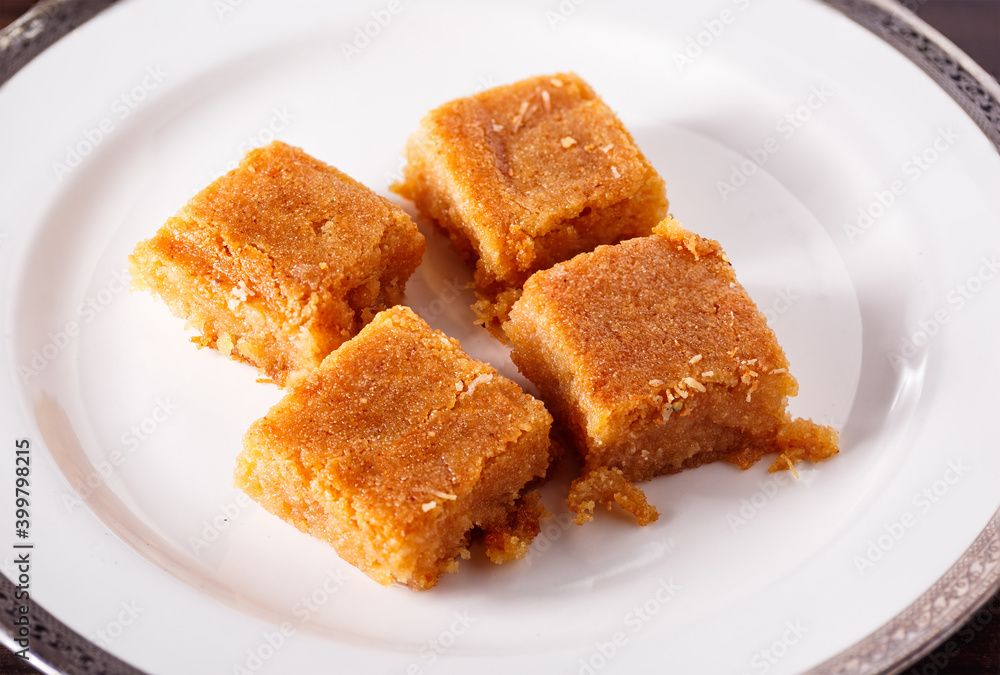 Middle Eastern Basbousa cake slices in a white plate; copy space Middle Eastern Basbousa cake slices in a white plate; copy space