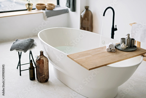 Foto White bathtub fills with foam water in a modern apartment with stylish loft-style interior design, home decor