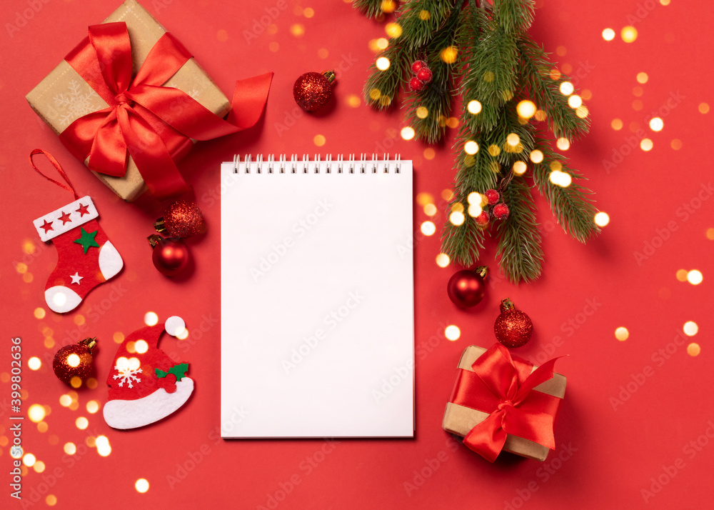 Christmas gifts boxes toys blank notepad red background Festive New Year concept