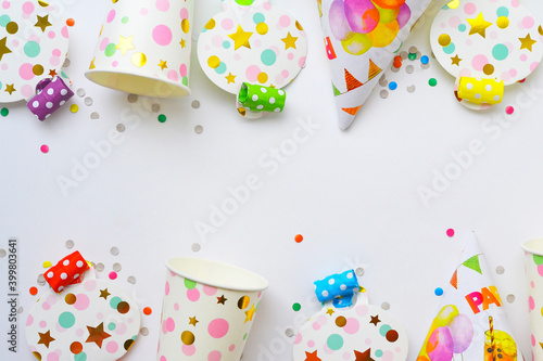 Birthday decoratoins on white background. Party hat and confetti. Birthday card with place for text.