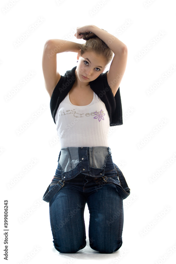 young girl kneels and straightens her hair on a white background young girl kneels and straightens her hair on a white background