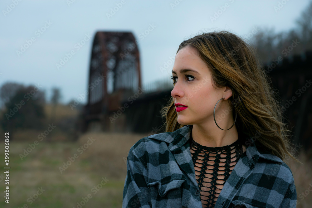 Candid Woman gazes beautifully with train tracks in background Candid Woman gazes beautifully with train tracks in background