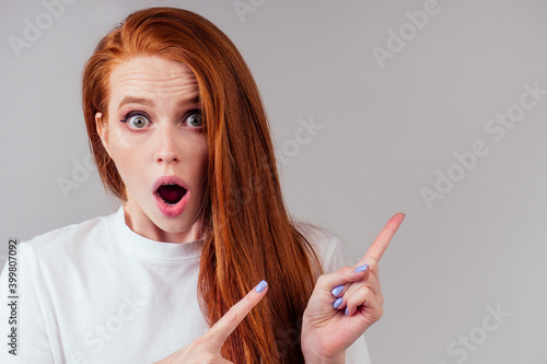 redhair ginger woman finger pointing copy space