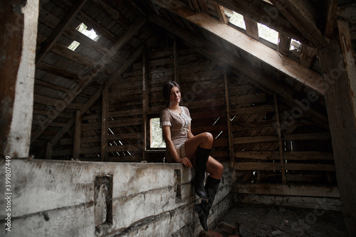Portrait of a village girl in the attic, smoking a cigarette and blowing smoke