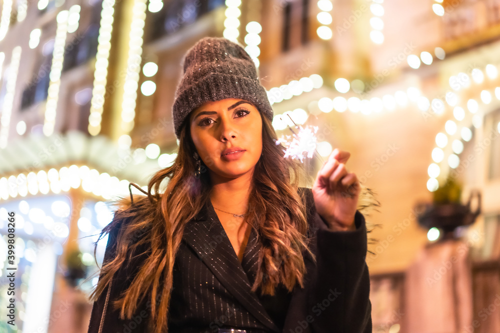 Christmas with Christmas lights in a beautiful building in the city, Caucasian young woman at night with some torches with fire in hand Christmas with Christmas lights in a beautiful building in the city, Caucasian young woman at night with some torches with fire in hand