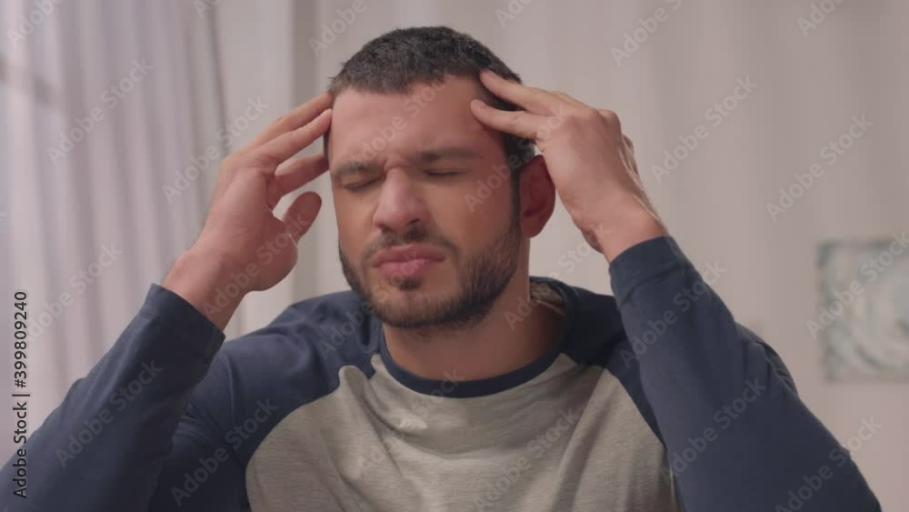 hispanic man doing self massage while suffering from migraine hispanic man doing self massage while suffering from migraine