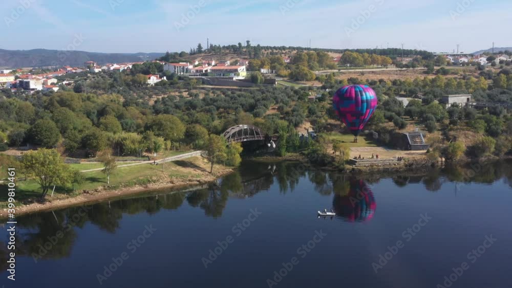 Aerial clip of a hot air colorful balloon by the lake Aerial clip of a hot air colorful balloon by the lake