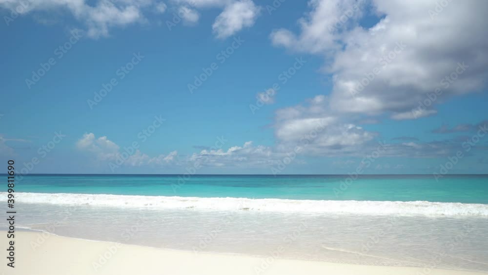 Exotic beach by the ocean with rolling waves on the sandy shore and blue sky Exotic beach by the ocean with rolling waves on the sandy shore and blue sky
