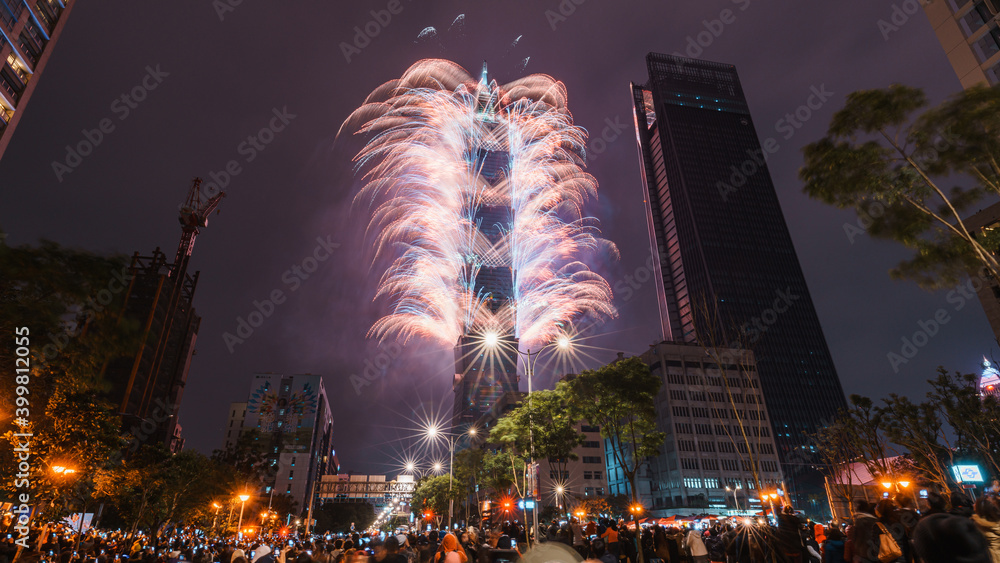Obraz premium Taipei City Night landscape and Taipei 101 skyscraper is lit up by fireworks. People watching and taking photos and videos around buildings to celebrate the new year event.