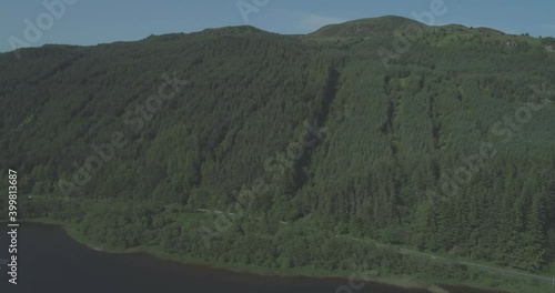 Aerial of cars travelling along a mountain road beside a loch in the Scottish Highlands photo