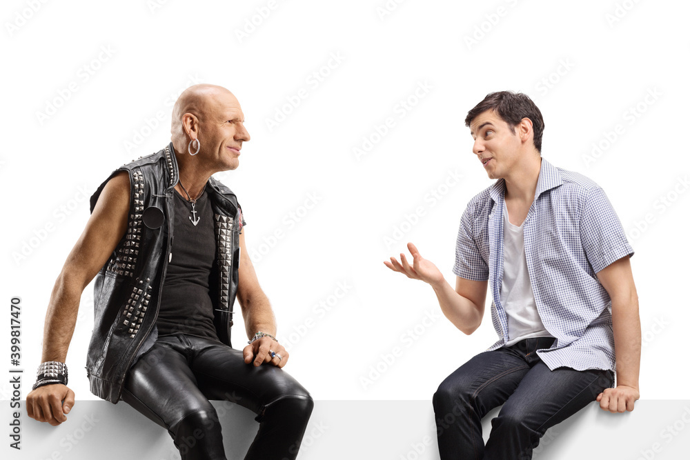 Guy talking to a punk in leather clotes and sitting on a panel
