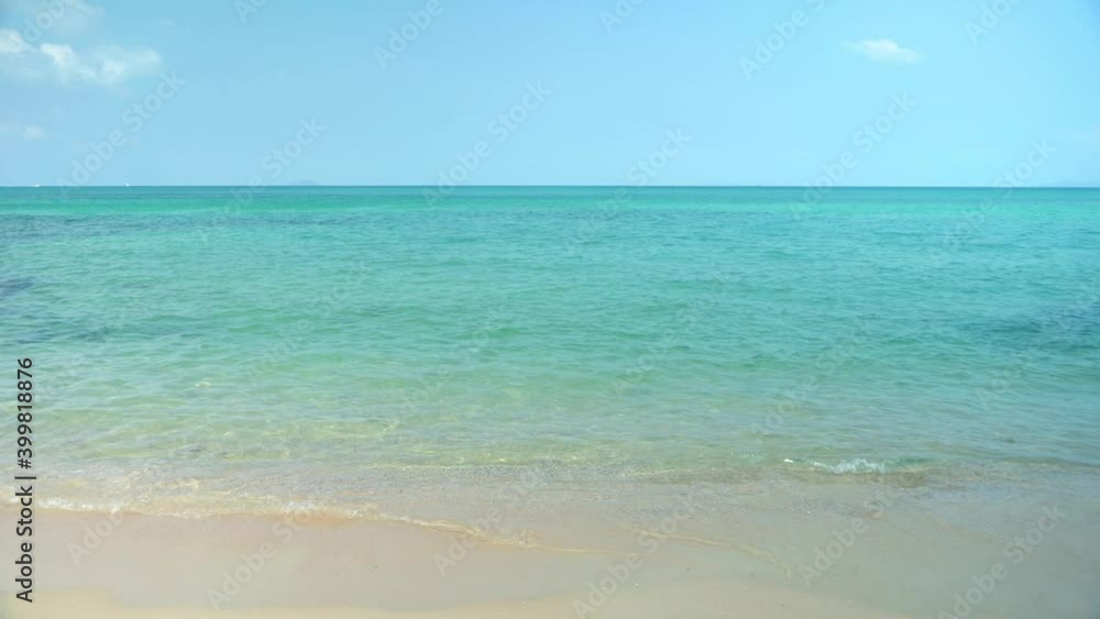 Exotic beach by the ocean with rolling waves on the sandy shore and blue sky Exotic beach by the ocean with rolling waves on the sandy shore and blue sky
