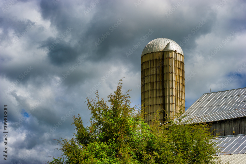 Stormy skies hang over a silo and barnroof in rural Tennessee