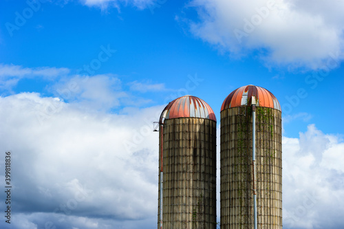 Two Silos against a partically cloudy sky photo