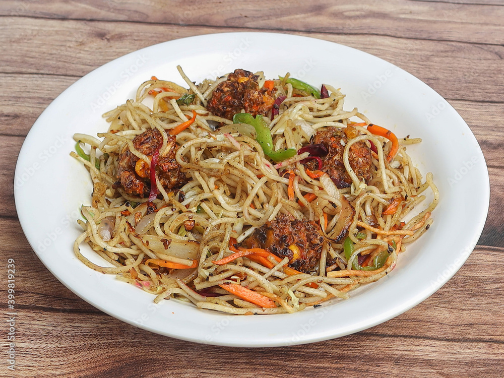 Manchurian Noodles a popular indo-chinese dish served over a rustic wooden background, selective focus