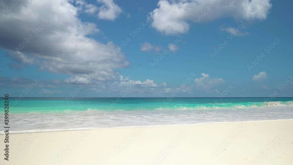 Exotic beach by the ocean with rolling waves on the sandy shore and blue sky Exotic beach by the ocean with rolling waves on the sandy shore and blue sky
