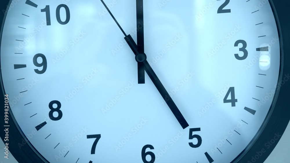 Black and white clock close up. Five clock on the dial Black and white clock close up. Five clock on the dial