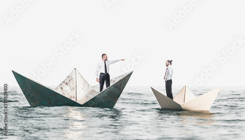 businesspeople on metal and paper boats.