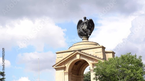 Statue of angel on building, panning left to right medium shot photo