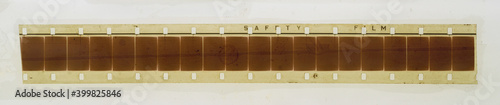 Konstfotografi one single blank long 16mm filmstrip or snip on white fixed by transparent sticky tape foil