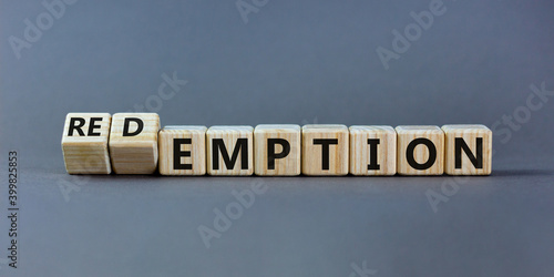 Redemption or emption symbol. Fliped a wooden cube and changed the word 'emption ' to 'redemption'. Beautiful grey background, copy space. Business and redemption or emption concept. photo