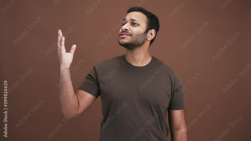 Delight and admiration. Inspired indian man showing Bellissimo gesture, looking aside with rapture. brown background Delight and admiration. Inspired indian man showing Bellissimo gesture, looking aside with rapture. brown background