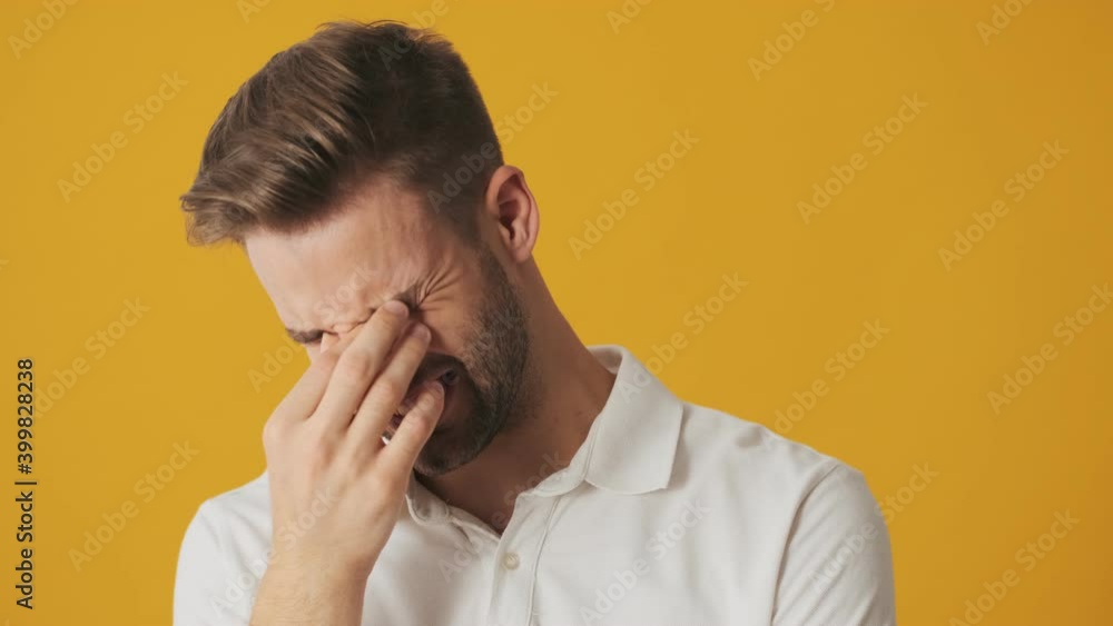 Handsome young displeased man with toothache isolated over yellow wall background Handsome young displeased man with toothache isolated over yellow wall background