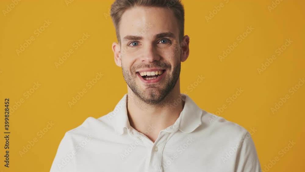Handsome young happy man isolated over yellow wall background Handsome young happy man isolated over yellow wall background
