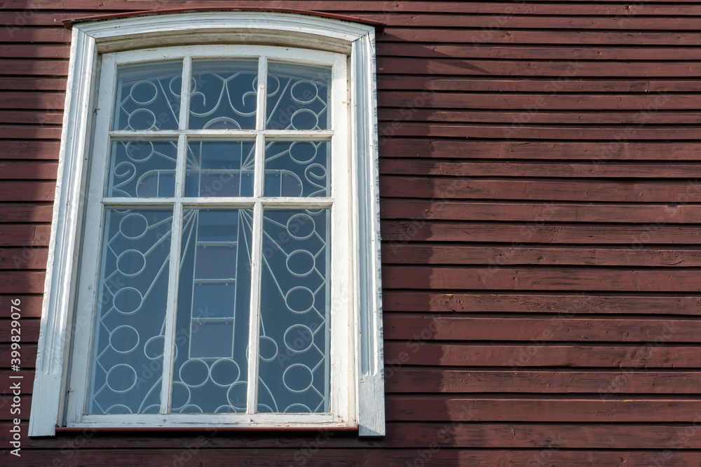 White wooden antique window on a wooden building. Old well-kept wooden house. Old Church and Windows with a cross. White wooden antique window on a wooden building. Old well-kept wooden house. Old Church and Windows with a cross.