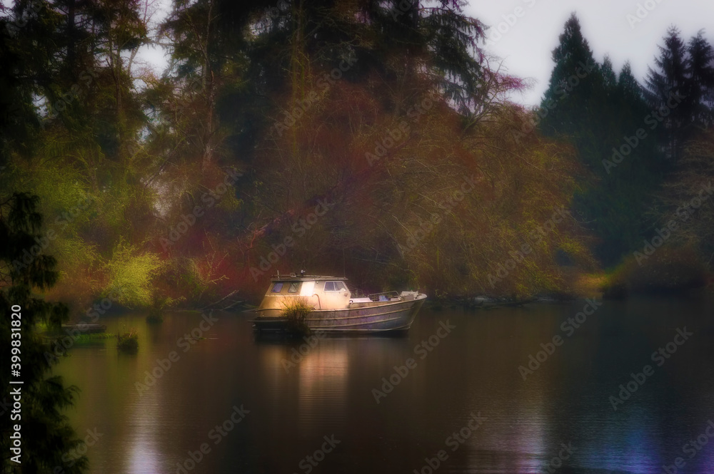 Fototapeta premium Boat sits in early evening light in misty weather.