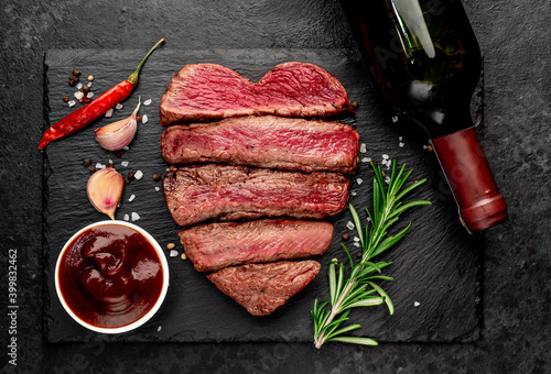 Wallpaper Mural Different degrees of roasting heart-shaped beef steak with spices and bottle of wine on a stone background. valentines day celebration concept Torontodigital.ca