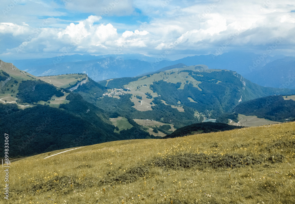 Beautiful view of the peaks of Monte Baldo. Stunning cloudy and panoramic view. Green Pastures in Italian Alps Beautiful view of the peaks of Monte Baldo. Stunning cloudy and panoramic view. Green Pastures in Italian Alps