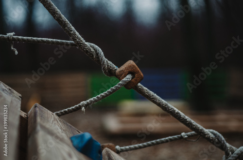 Close up of rope twirled and knotted on a wooden construction in the park with cork elements