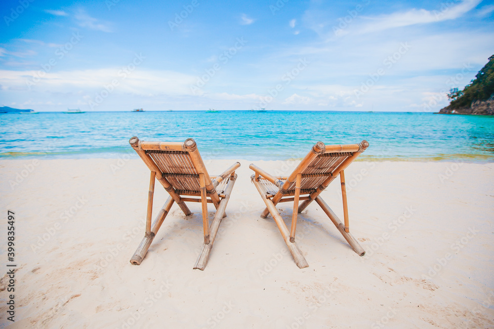 White lounge chairs on a beautiful tropical beach