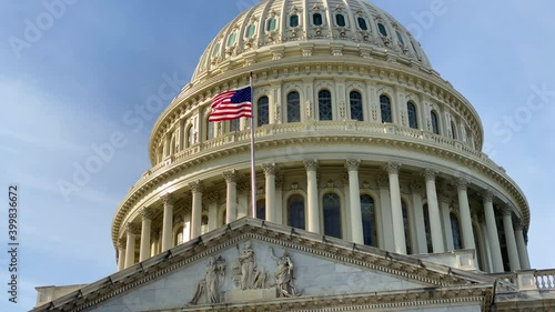A close up of the United States Capitol dome and the waving US national flag