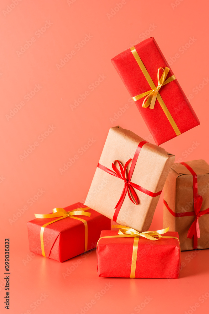 Gifts piled up in a pile, wrapped in paper and tied with ribbon. Pink background Gifts piled up in a pile, wrapped in paper and tied with ribbon. Pink background