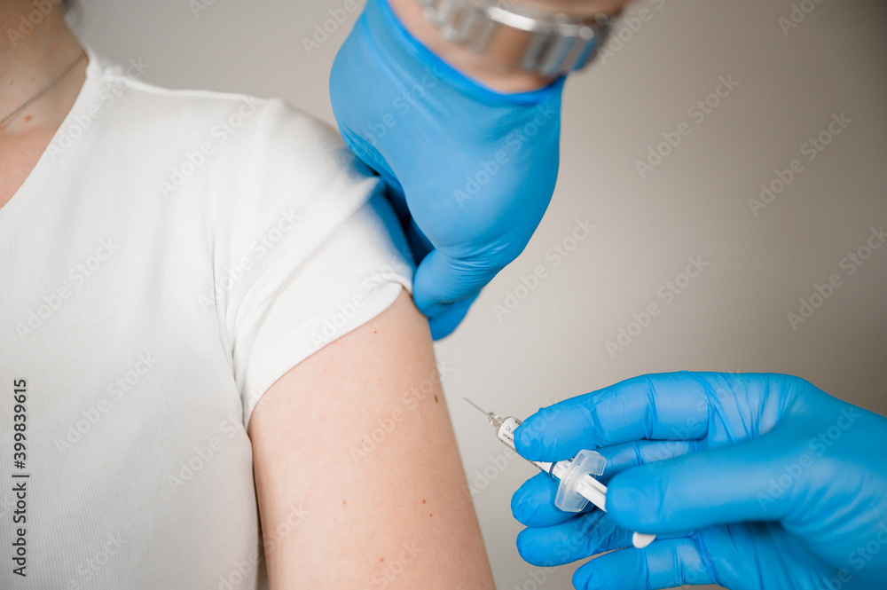 Doctor injecting Covid Vaccine into a patients arm: Curing the Corona Pandemic with mass Vaccination Doctor injecting Covid Vaccine into a patients arm: Curing the Corona Pandemic with mass Vaccination