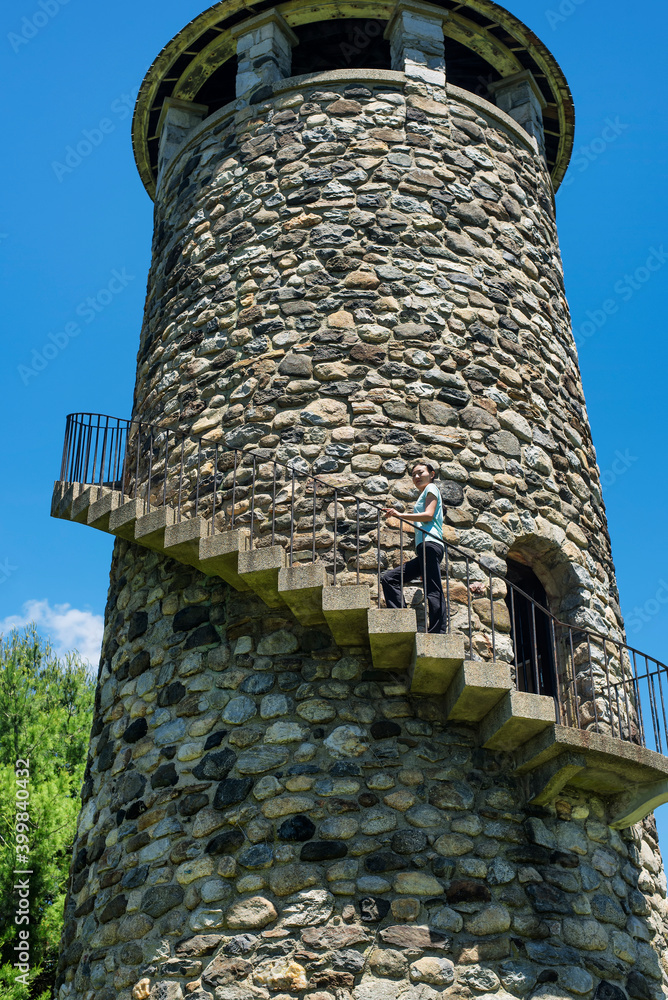 A chinese woman climbing up a stone tower