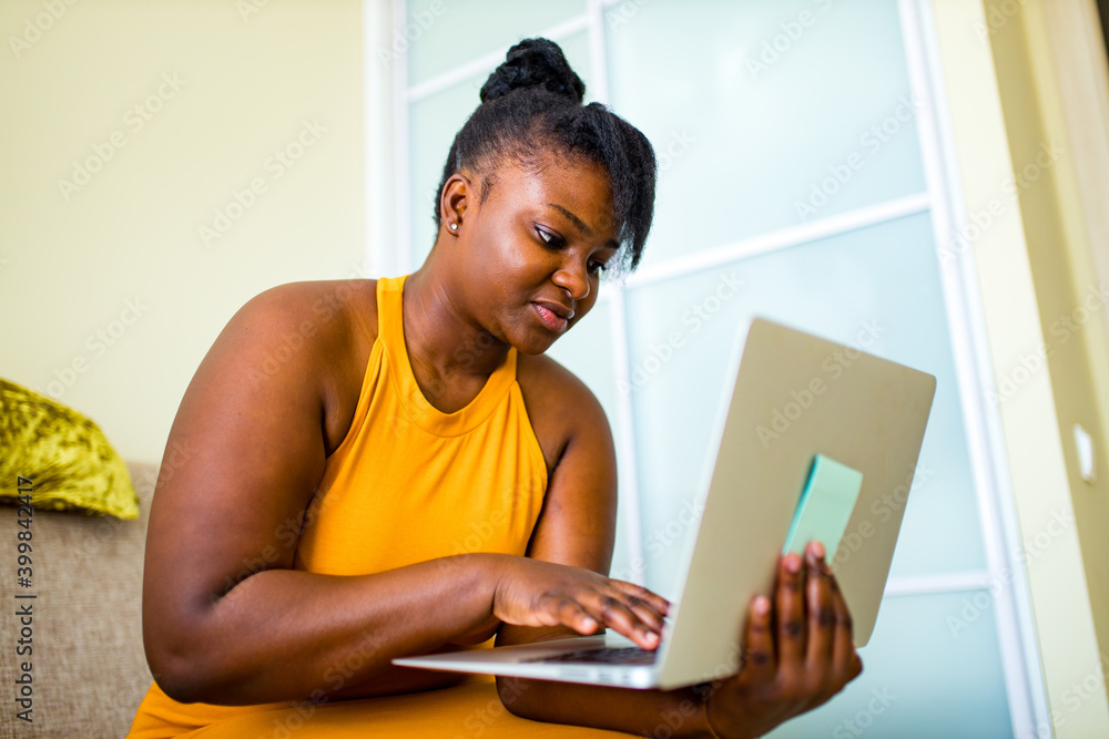 mixed race woman working by laptop in living room mixed race woman working by laptop in living room