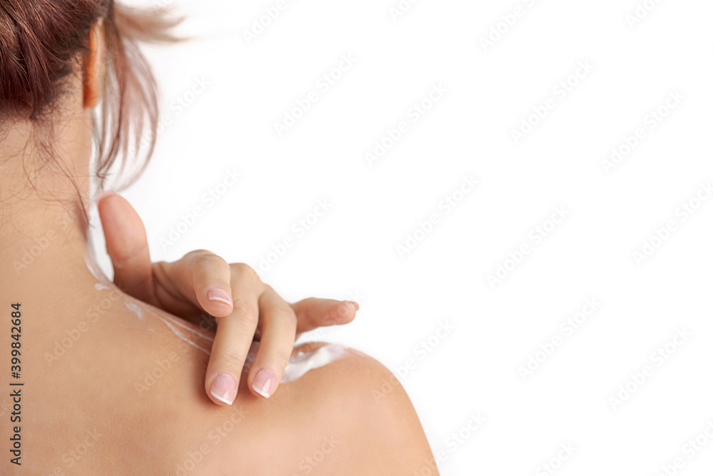 Obraz premium red hair woman's hand applying cream on her shoulder. Concept of smooth skin, skincare, cosmetics, wellness center, healthy lifestyle
