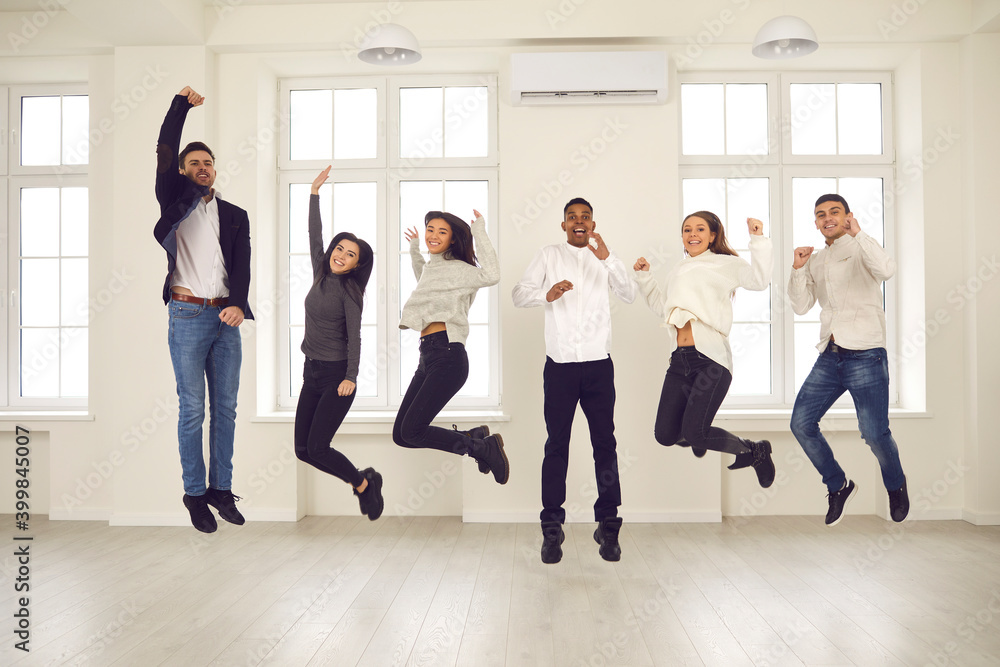 Fototapeta premium Group of happy energetic colleagues or friends jumping all together and celebrating success