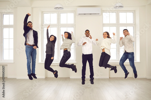 Fototapeta Naklejka Na Ścianę i Meble -  Group of happy energetic colleagues or friends jumping all together and celebrating success
