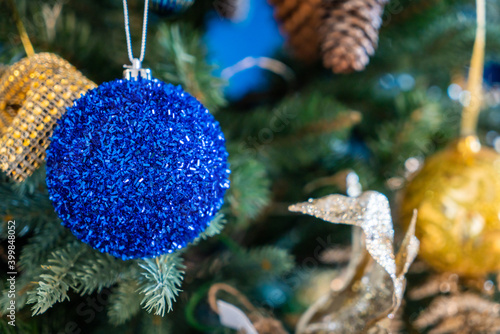 Christmas background, living branches of spruce. Christmas decorations, Santa's mitten Pink and gold balls and Christmas bells. Festive background.
