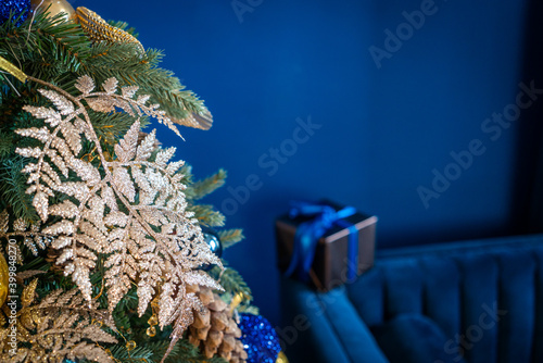 Christmas background, living branches of spruce. Christmas decorations, Santa's mitten Pink and gold balls and Christmas bells. Festive background.