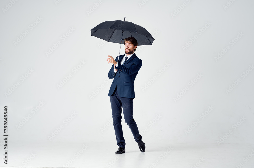 elegant gentleman with a dark umbrella on a light background and a classic suit elegant gentleman with a dark umbrella on a light background and a classic suit
