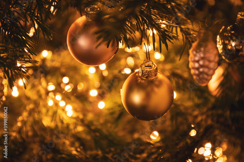 golden bauble on a decorated Christmas tree with festive lights