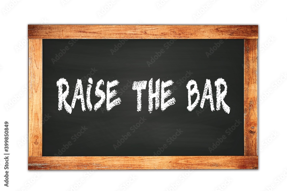 Obraz premium RAISE THE BAR text written on wooden frame school blackboard.